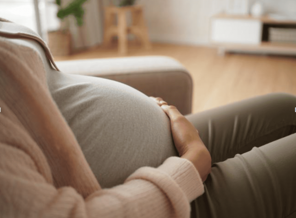 photo d’une femme enceinte assise dans son salon